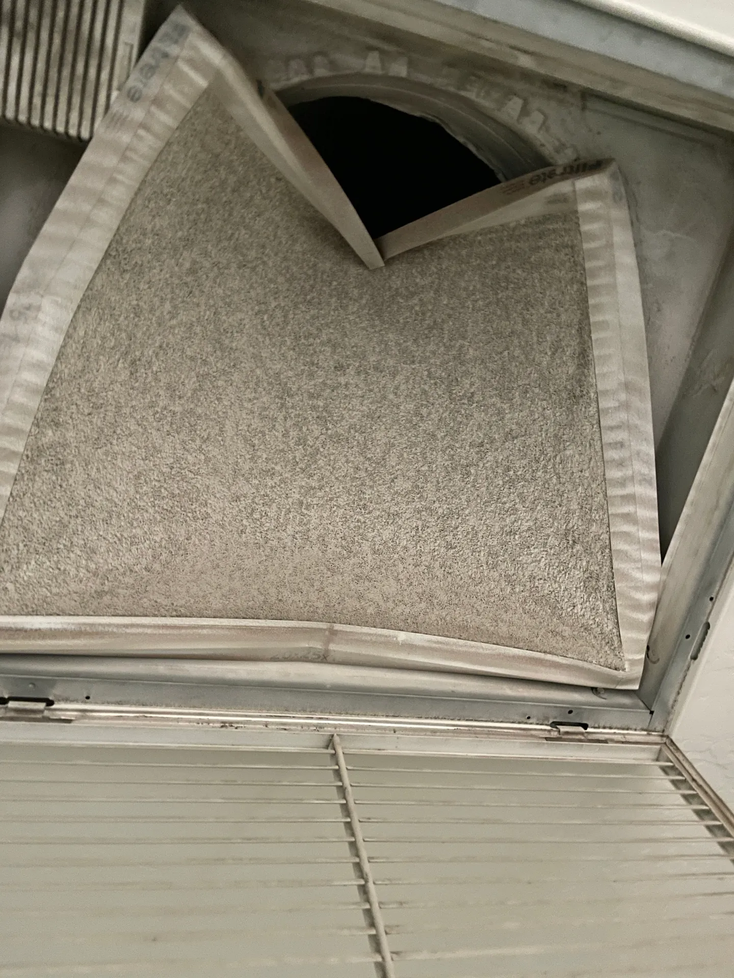 Dirty HVAC return air filter bowed inward from heavy buildup