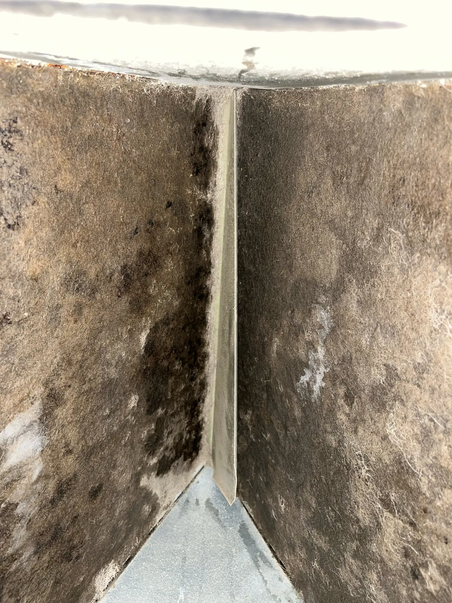 Interior duct surface showing heavy dust and contamination buildup