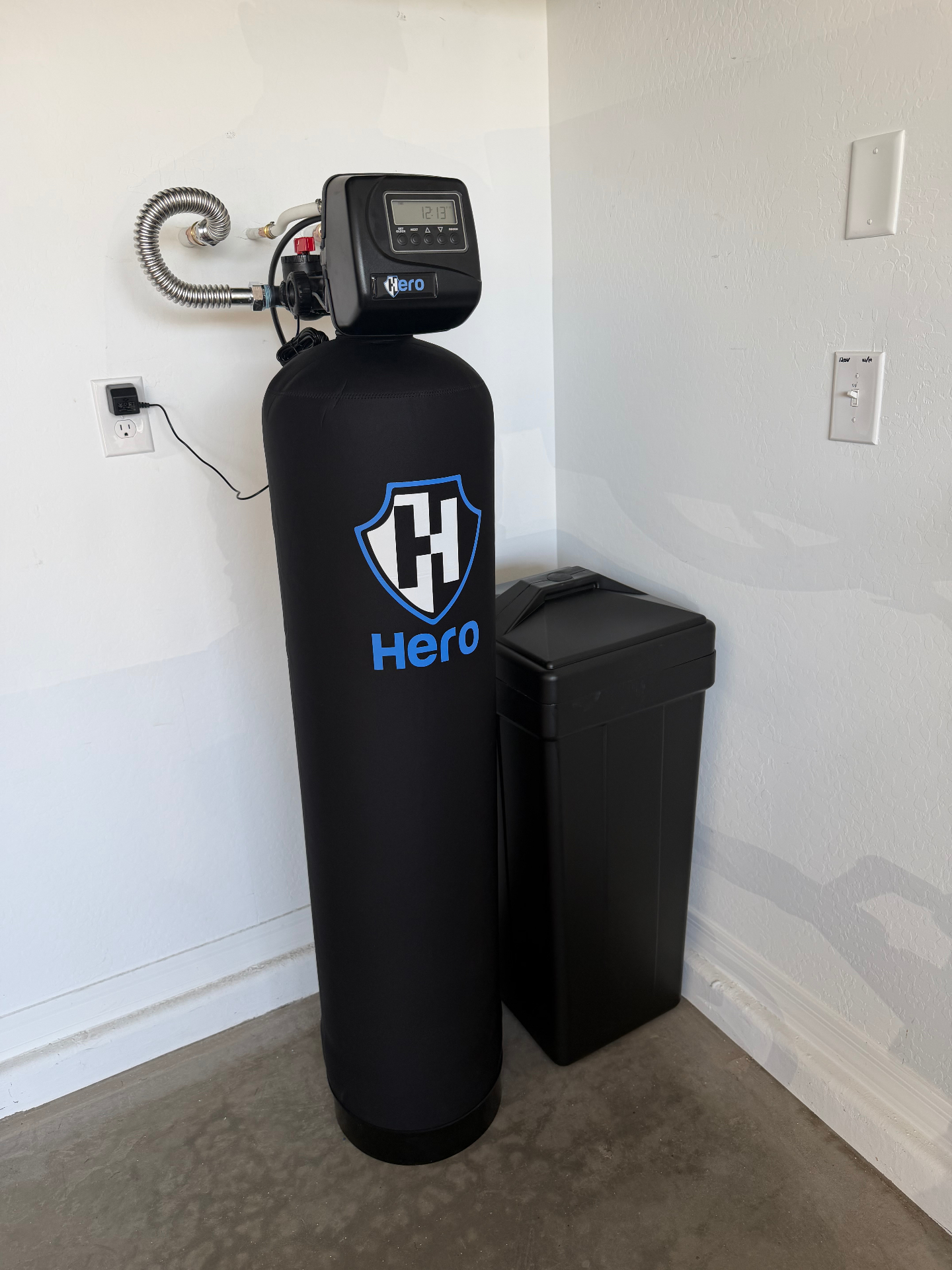 Whole-house water softener system with brine tank installed in an Arizona garage by American Home Pros of Arizona