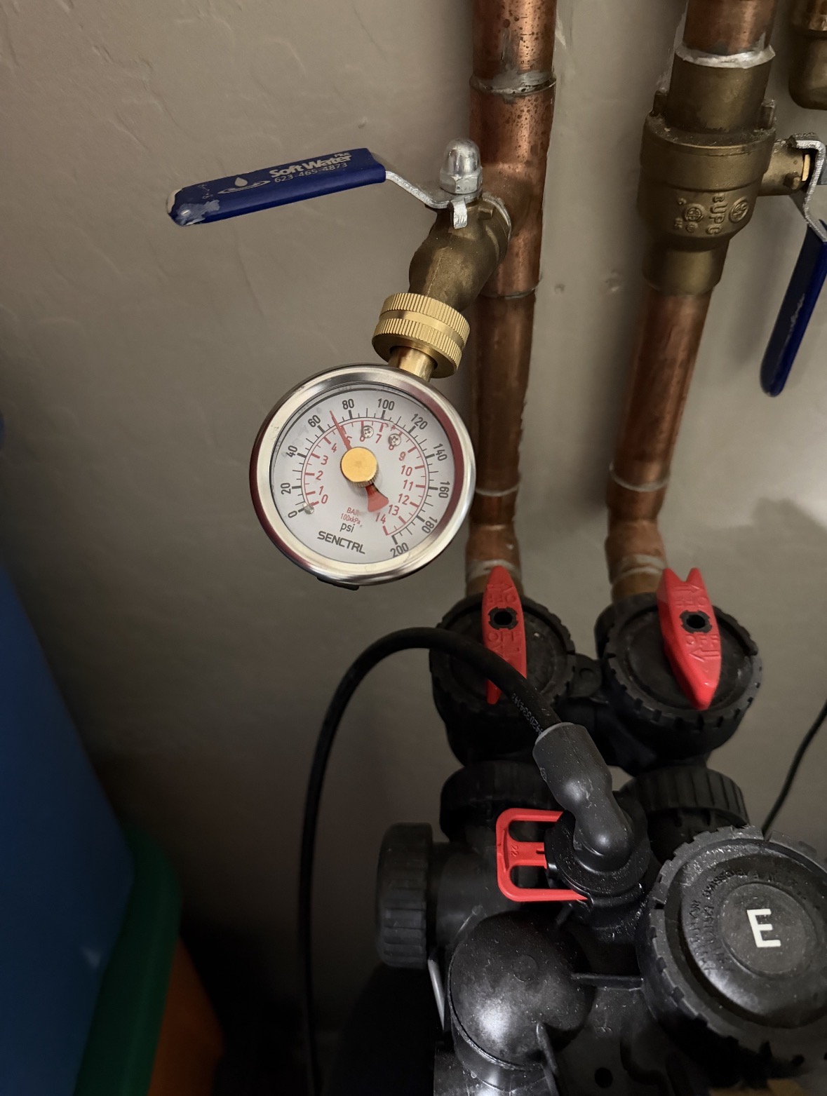 Brass bell-shaped pressure reducing valve installed on a residential main water line with a pressure gauge, in Arizona